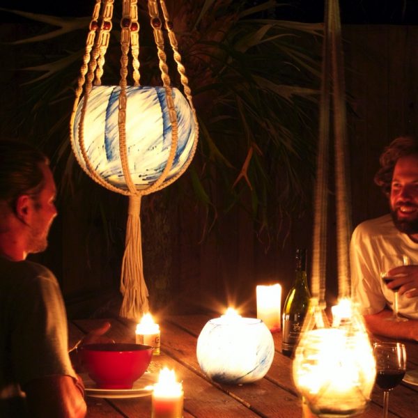 A lantern in a macrame hanger adds to the relaxed setting you enjoy, outside or in. Photo by Frank Gumley.