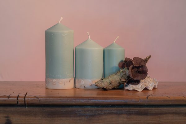 Essential oils of Himalayan Patchouli and Sandalwood create a sophisticated scent reminiscent of the swinging 60s' counter-culture. Teal coloured, this elegant candle features a crisp white base embedded with river pebbles.